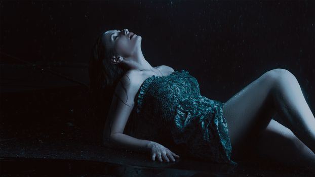 A captivating portrait of a woman in the rain, emphasizing beauty and fashion with a moody atmosphere.