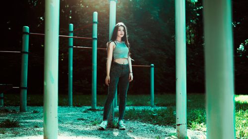 Free Stylish young woman posing confidently in a sunlit outdoor park setting. Stock Photo