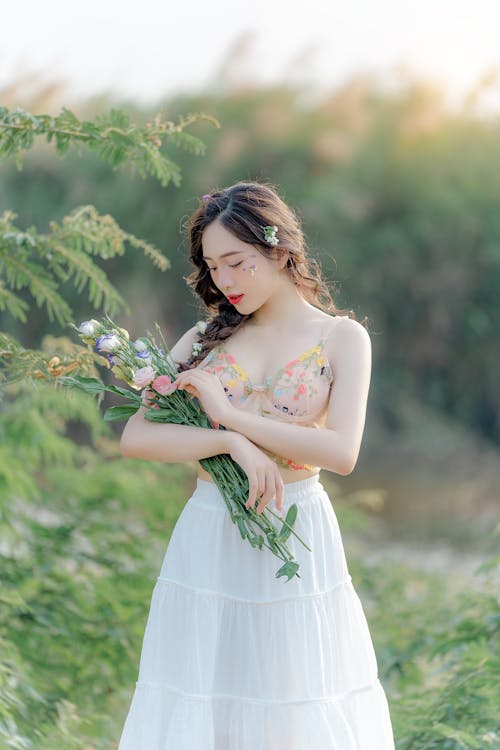 A woman in a white dress holding flowers
