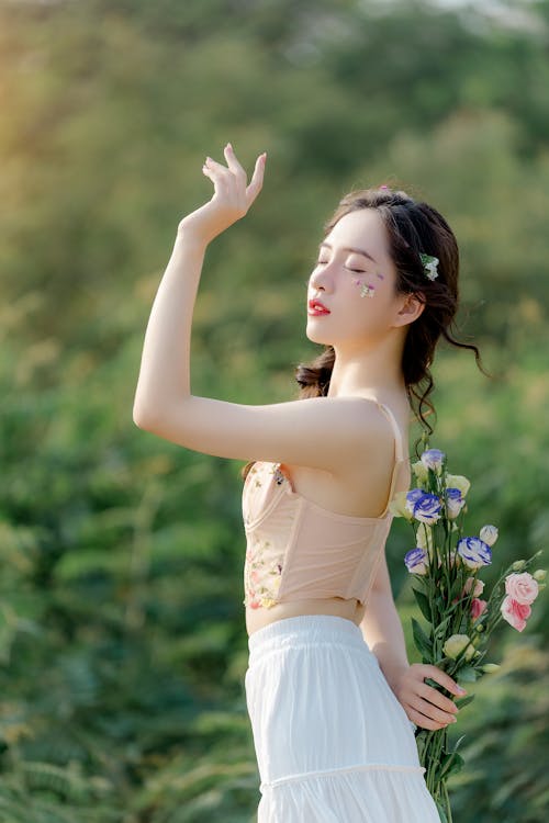 A woman in a white dress is holding flowers