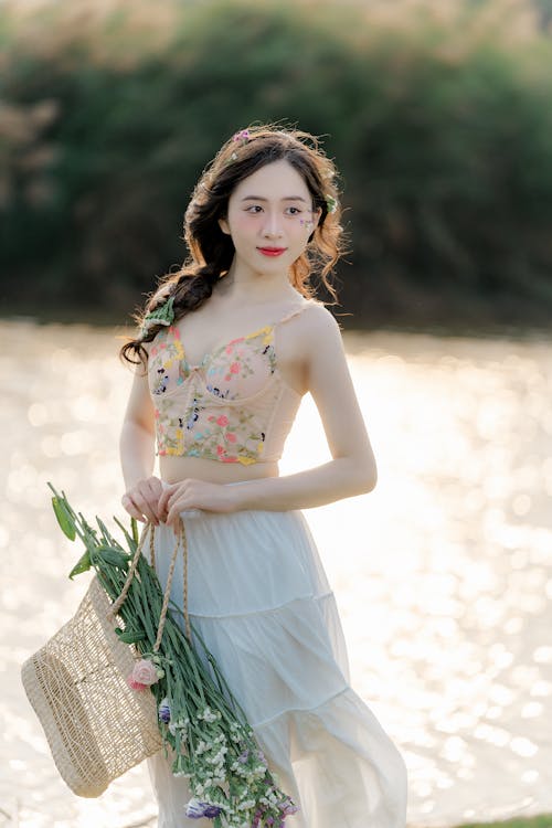 A beautiful young woman in a floral dress holding a basket