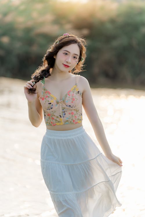 A woman in a skirt and top standing in the water