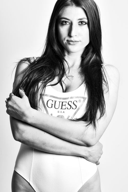 Free Stylish black and white portrait of a woman in a bodysuit with crossed arms. Stock Photo