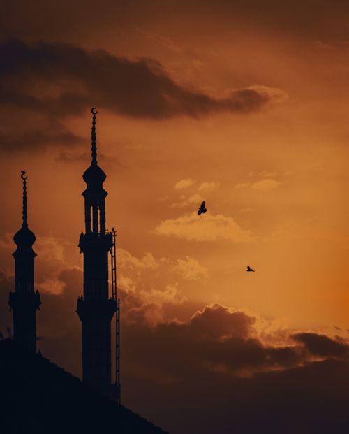 Free Silhouette of mosque minarets against a vibrant sunset sky in Shopian, Kashmir. Stock Photo
