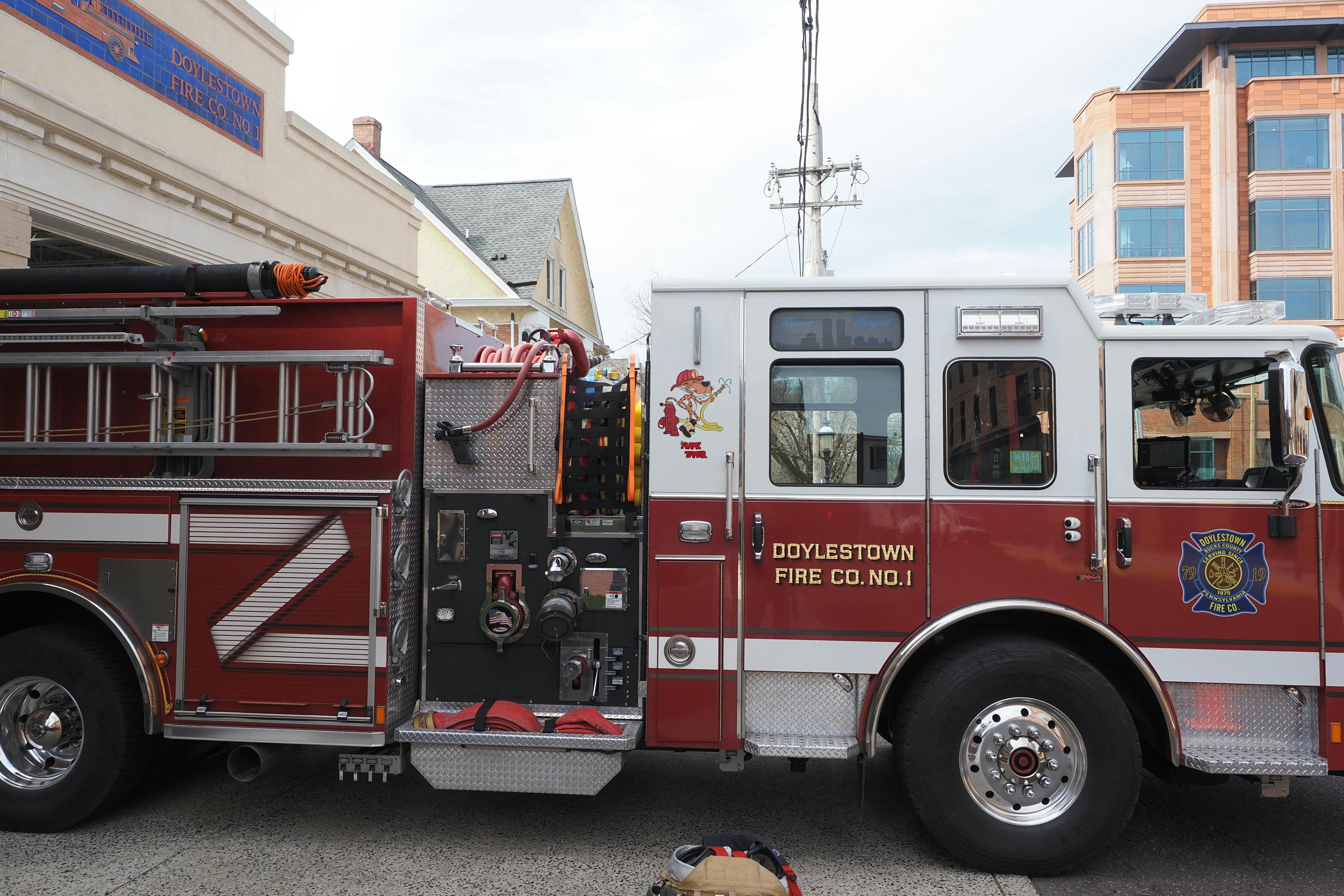Red Doylestown fire truck parked on city street, ready for action.