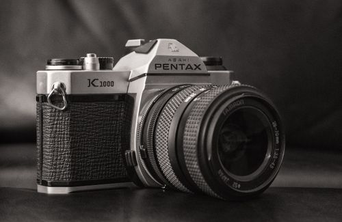Free A detailed black and white image of a classic Pentax film camera, highlighting its vintage design. Stock Photo