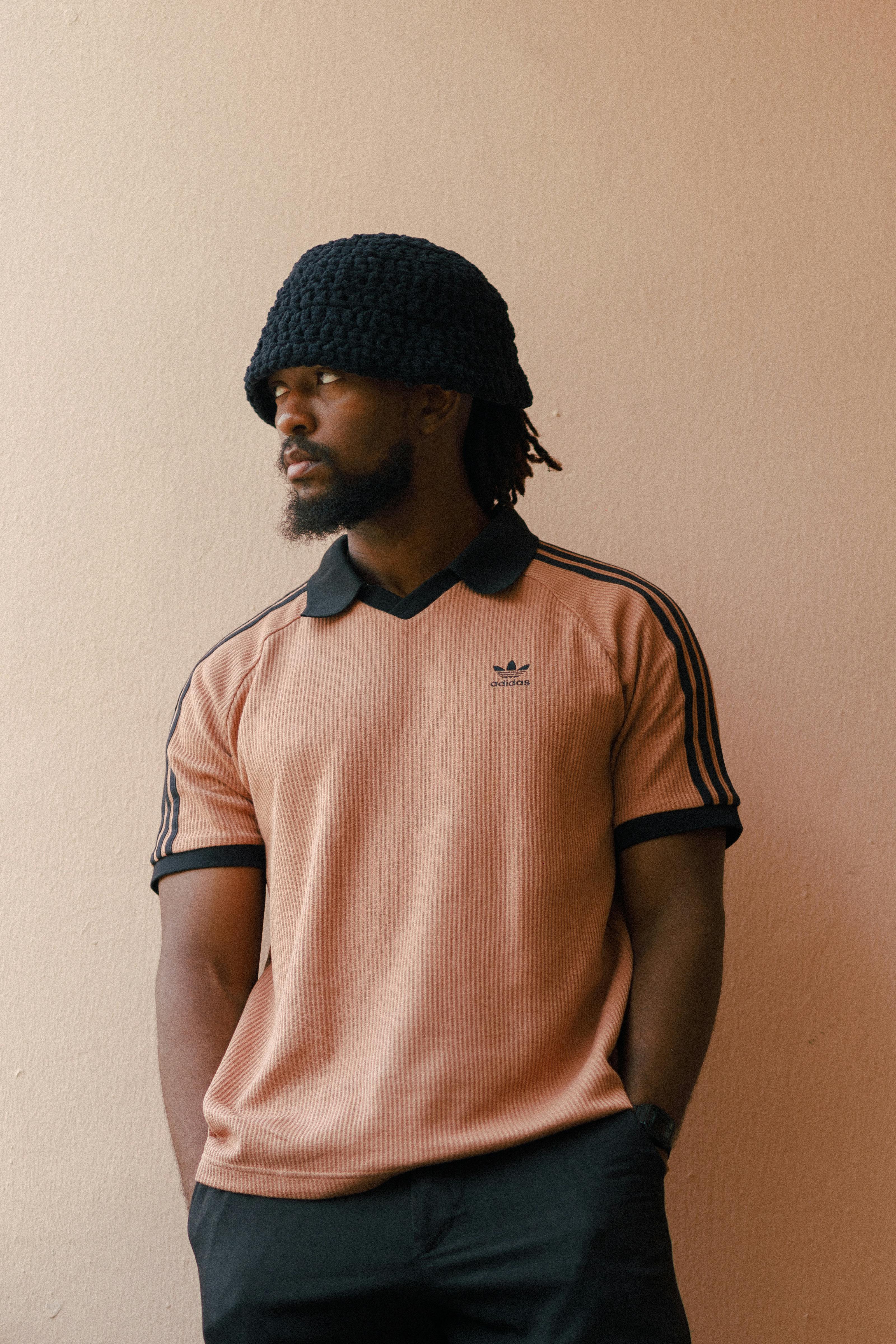 Portrait of a man in Lagos wearing a fashionable hat and polo shirt.
