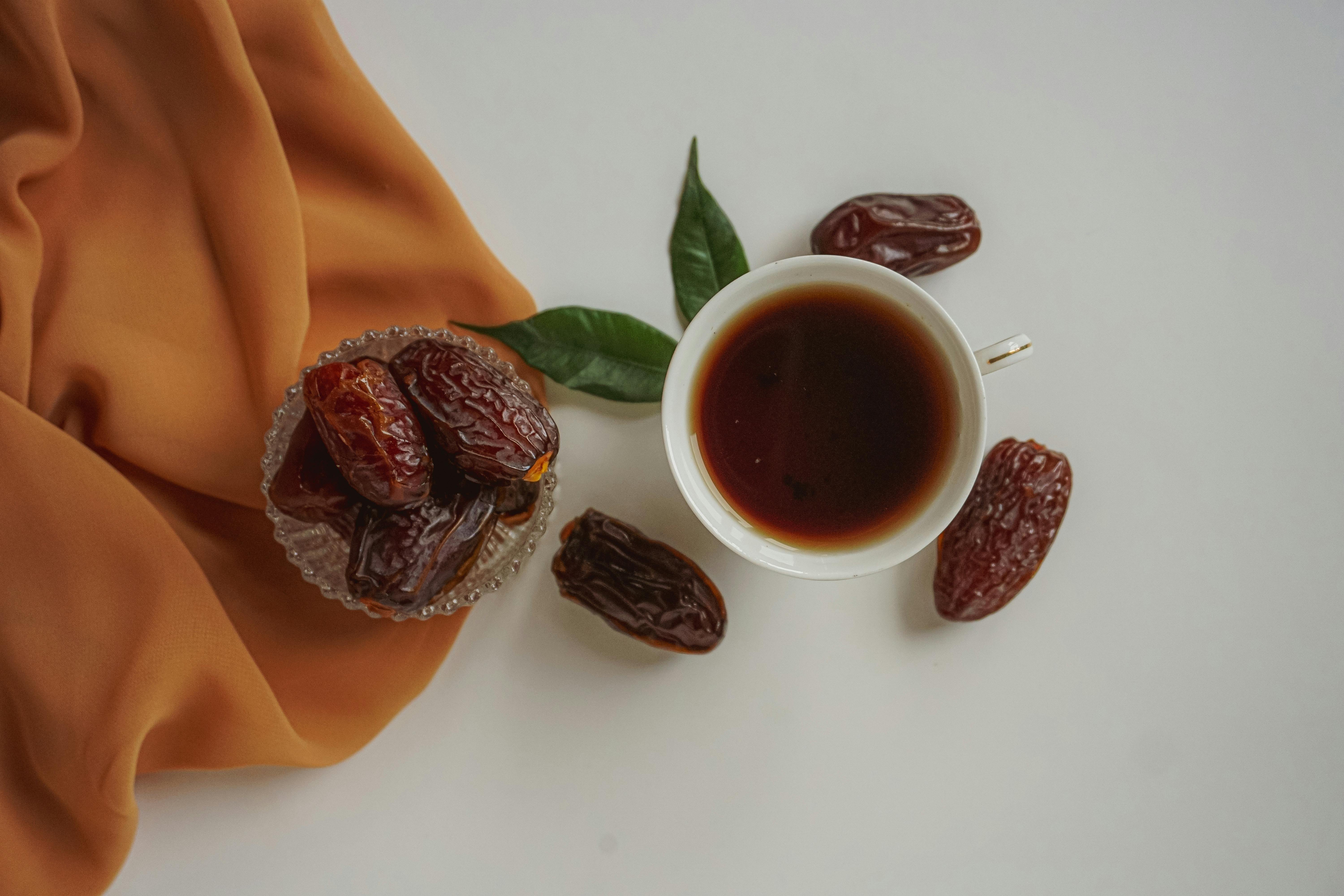 Aerial shot of a cup of tea and dates on a fabric surface, perfect for health and lifestyle themes.