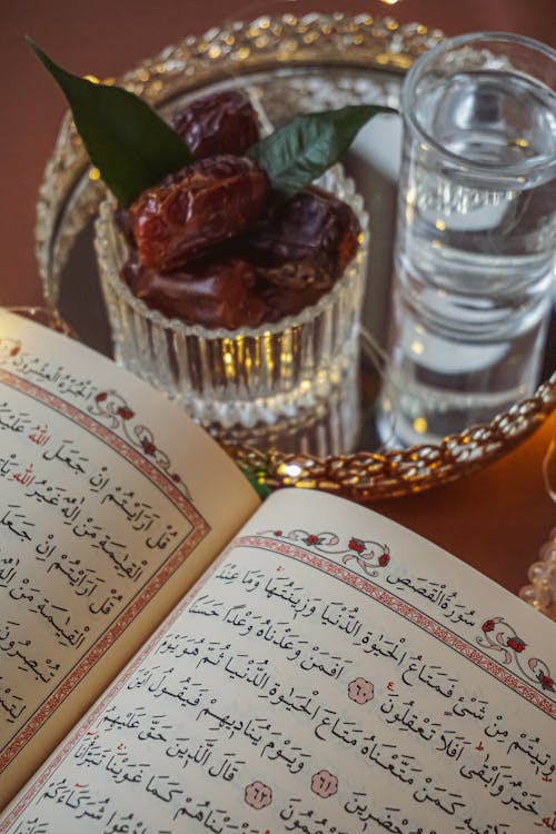 A quran and a glass of water on a tray