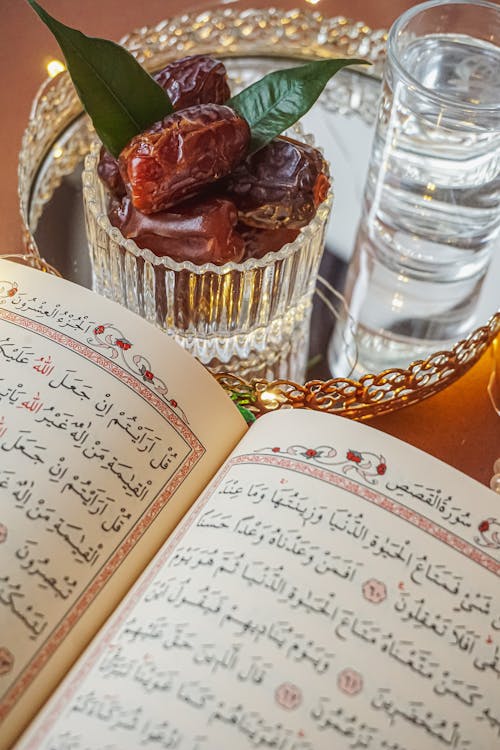 A quran and a glass of water on a tray