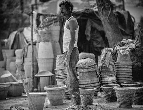 A man stands in front of a pottery shop