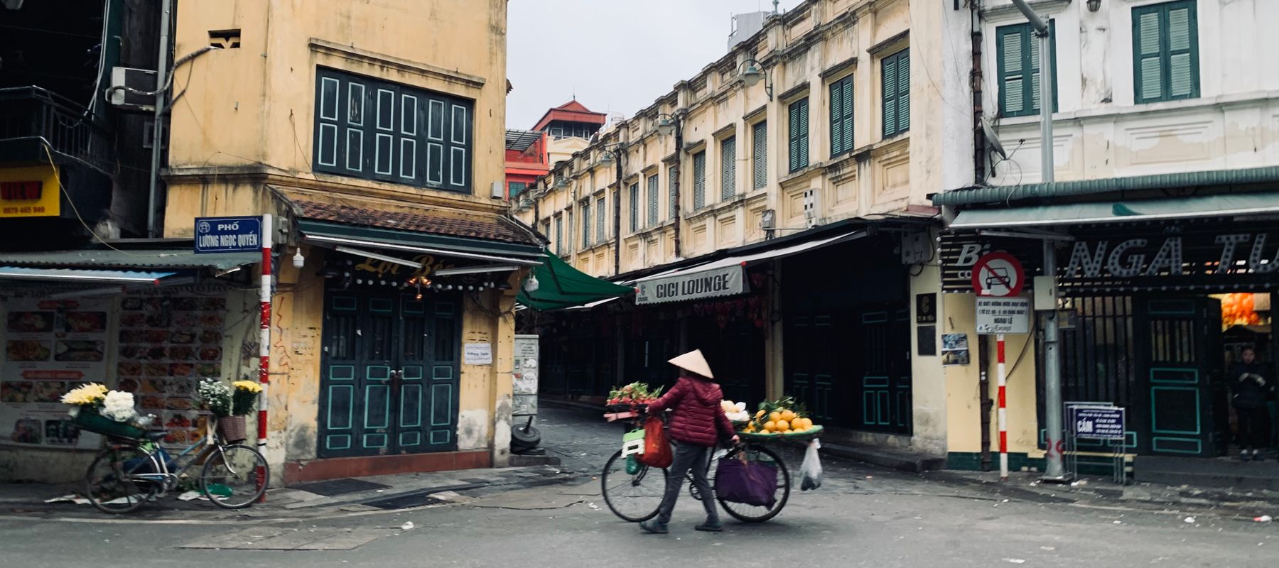 Street vendor with a bicycle in the urban market of Hanoi, Vietnam.