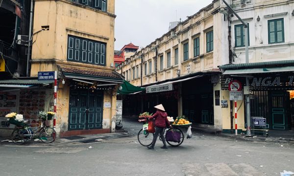 Street vendor with a bicycle in the urban market of Hanoi, Vietnam.