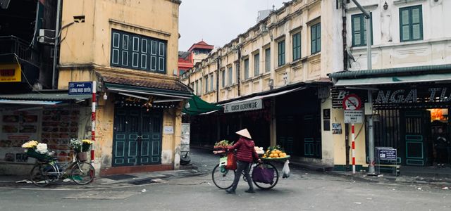 Street vendor with a bicycle in the urban market of Hanoi, Vietnam.