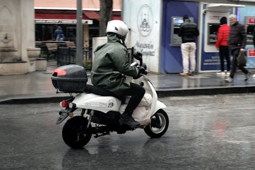 A man riding a motorcycle on a rainy day