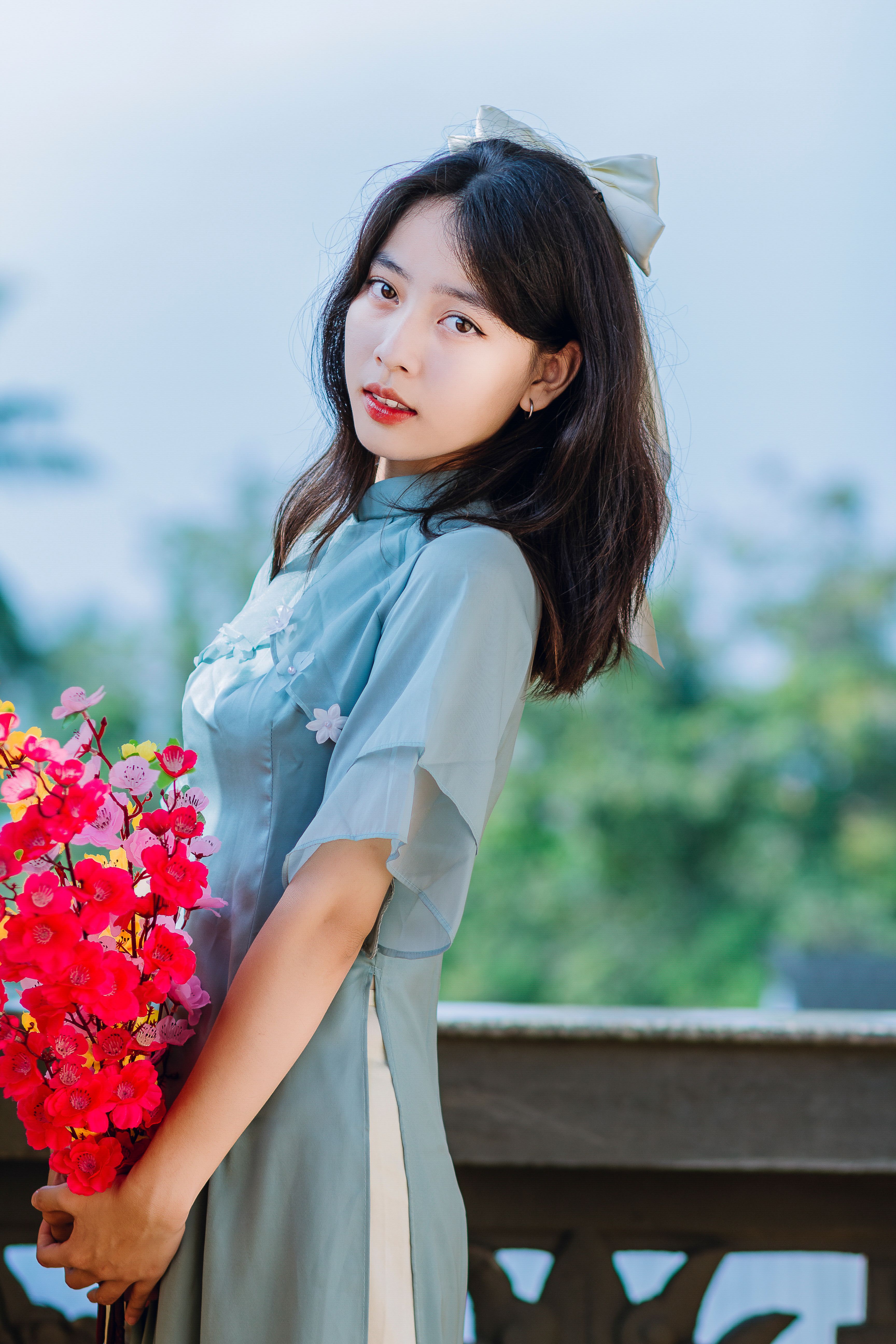 Woman in Traditional Clothing Posing Holding Flowers · Free Stock Photo