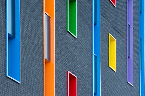 A close up of a building with many different colored windows