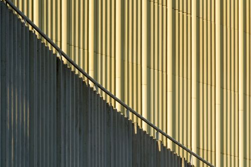 Free Dynamic view of a modern facade with cast shadows and a metal railing. Stock Photo