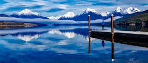 白雪皑皑的山脉倒映在宁静的湖水中，更显户外环境的幽静