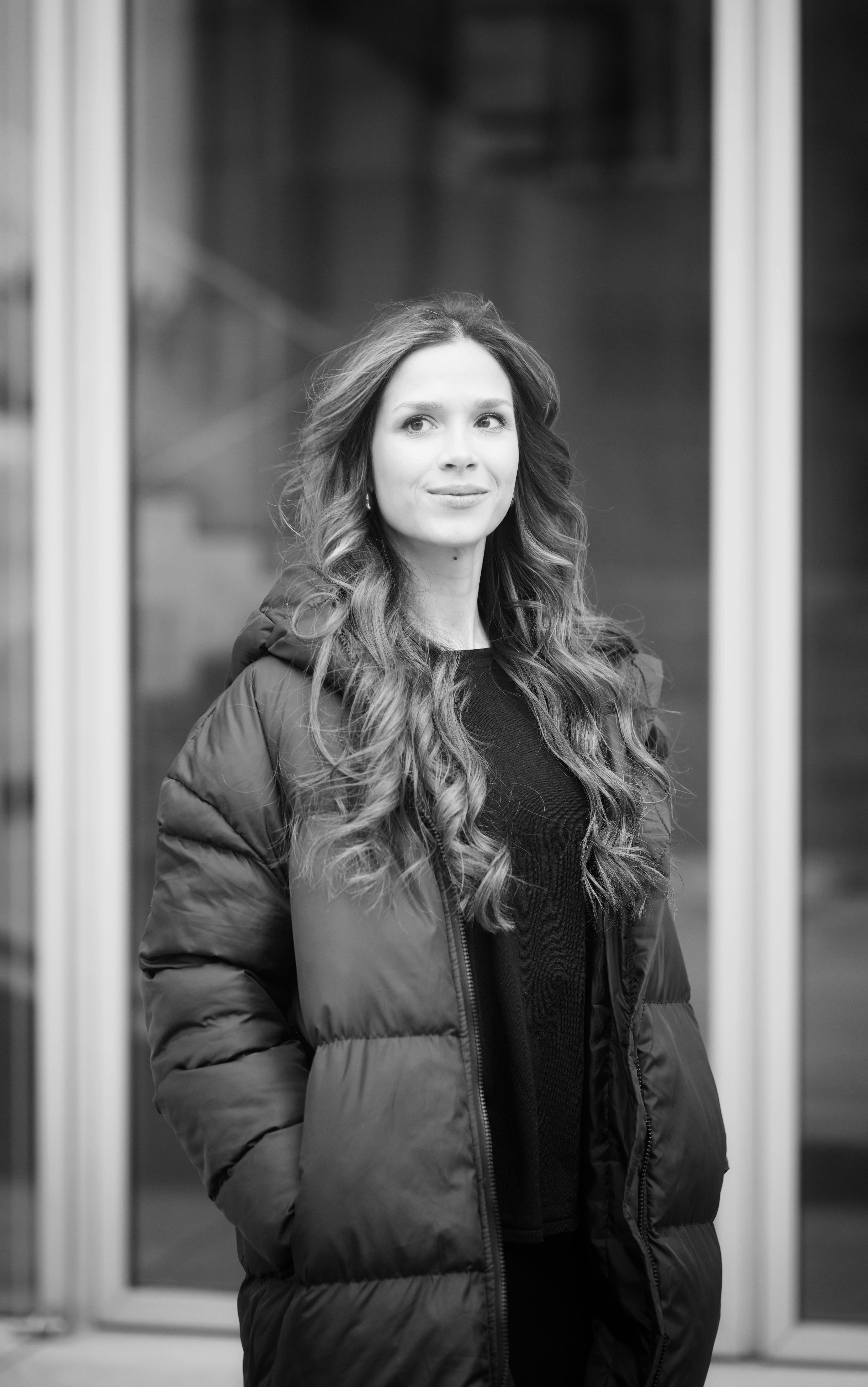 Urban black and white portrait of a fashionable young woman in winter attire.