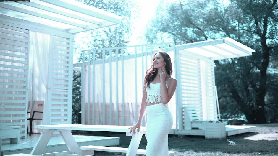 Woman in White Dress Standing Beside White Wooden Picnic Table
