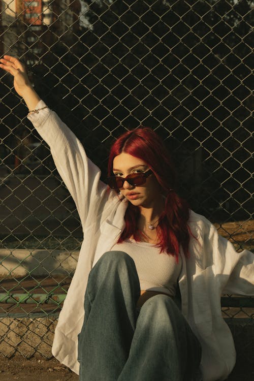 A woman with red hair sitting on the ground