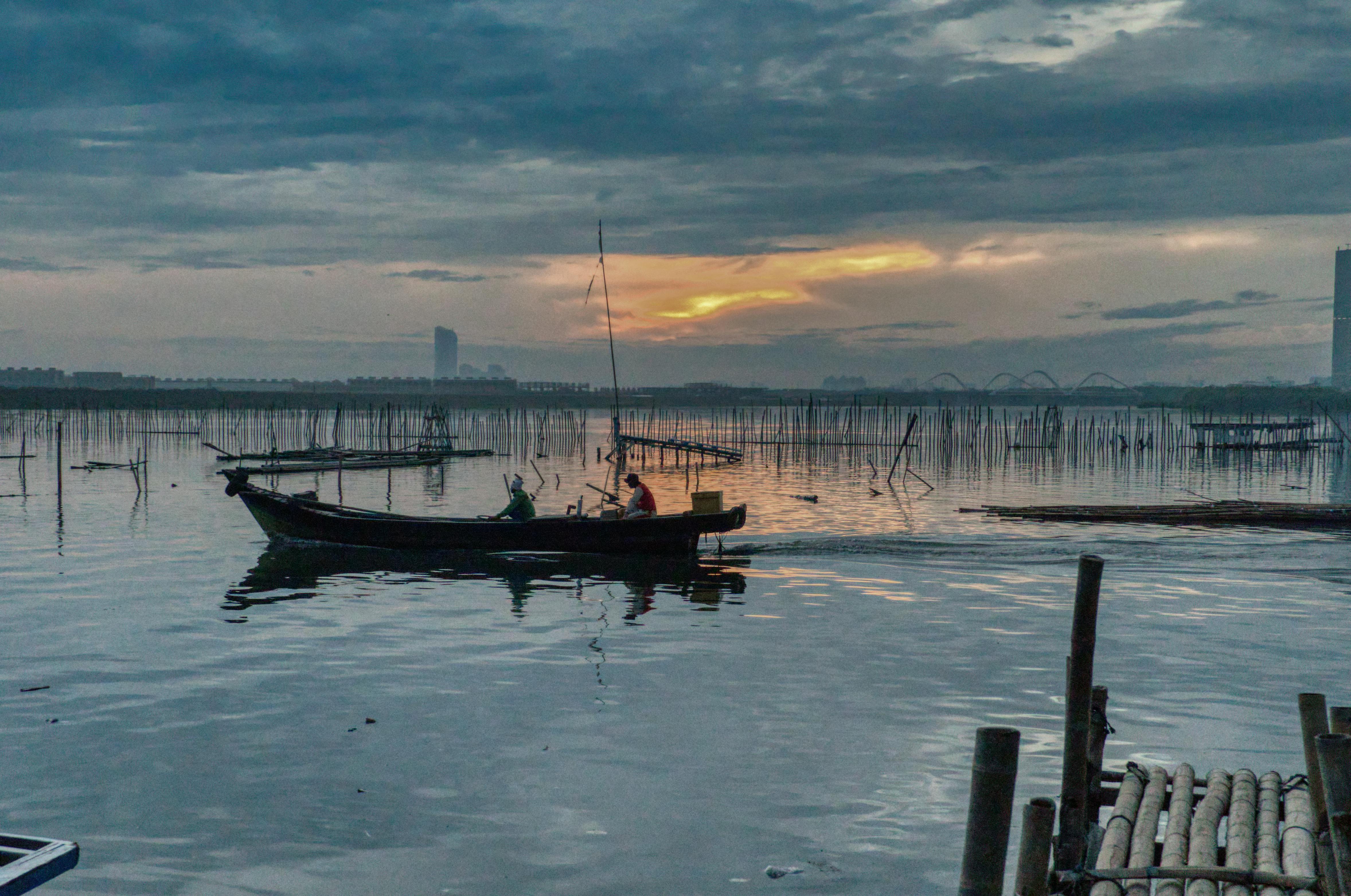 日落时分，雅加达附近水域的渔民在船上呈现出一片宁静景色