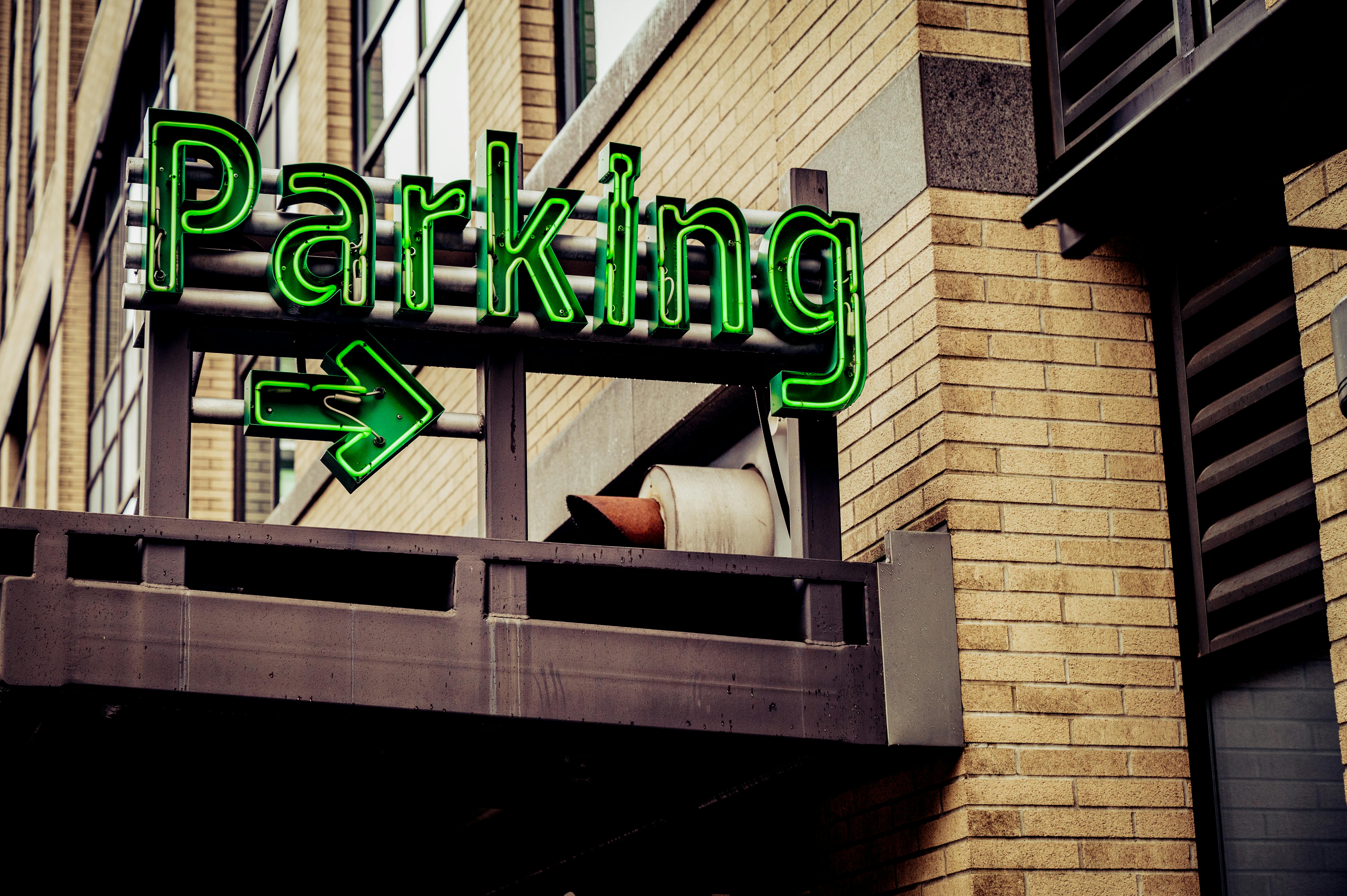 A neon green parking sign with an arrow in downtown Portland, Oregon.