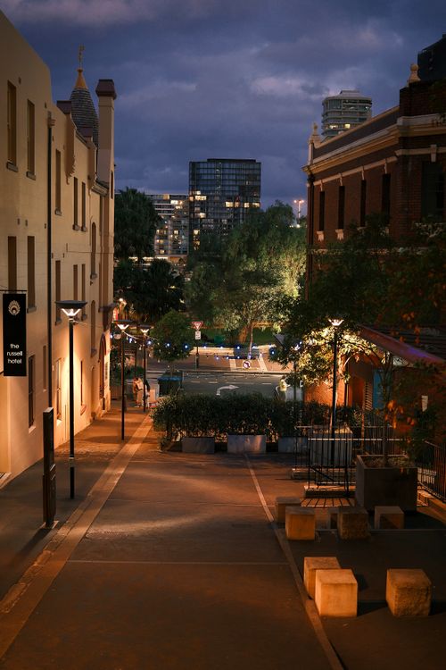 Free Tranquil city street scene at dusk with warm lighting and urban architecture. Stock Photo