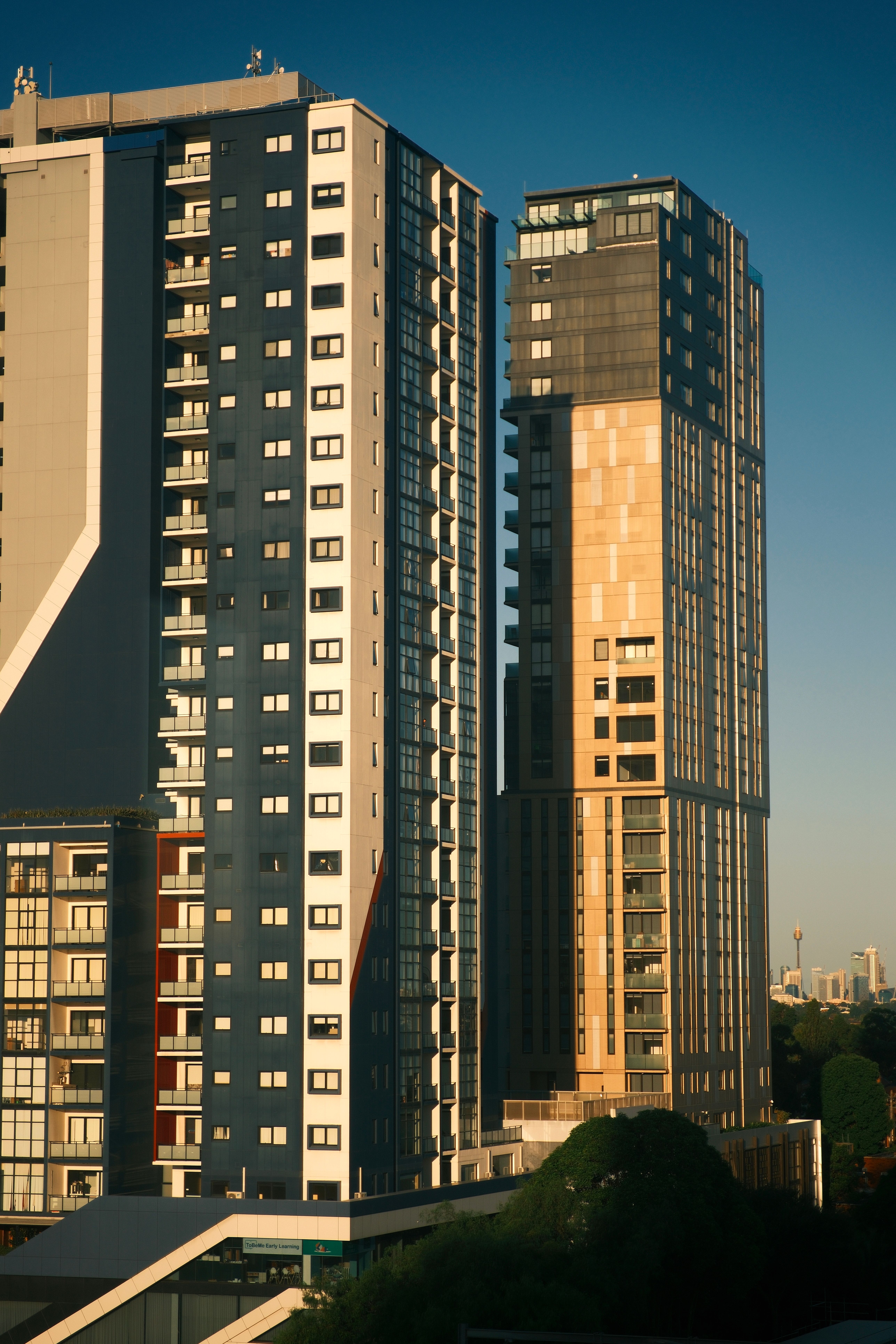 Contemporary high-rise apartment buildings against a clear sky, featuring urban architecture.