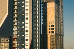 Contemporary high-rise apartment buildings against a clear sky, featuring urban architecture.