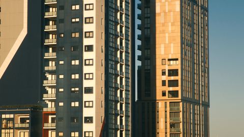 Contemporary high-rise apartment buildings against a clear sky, featuring urban architecture.