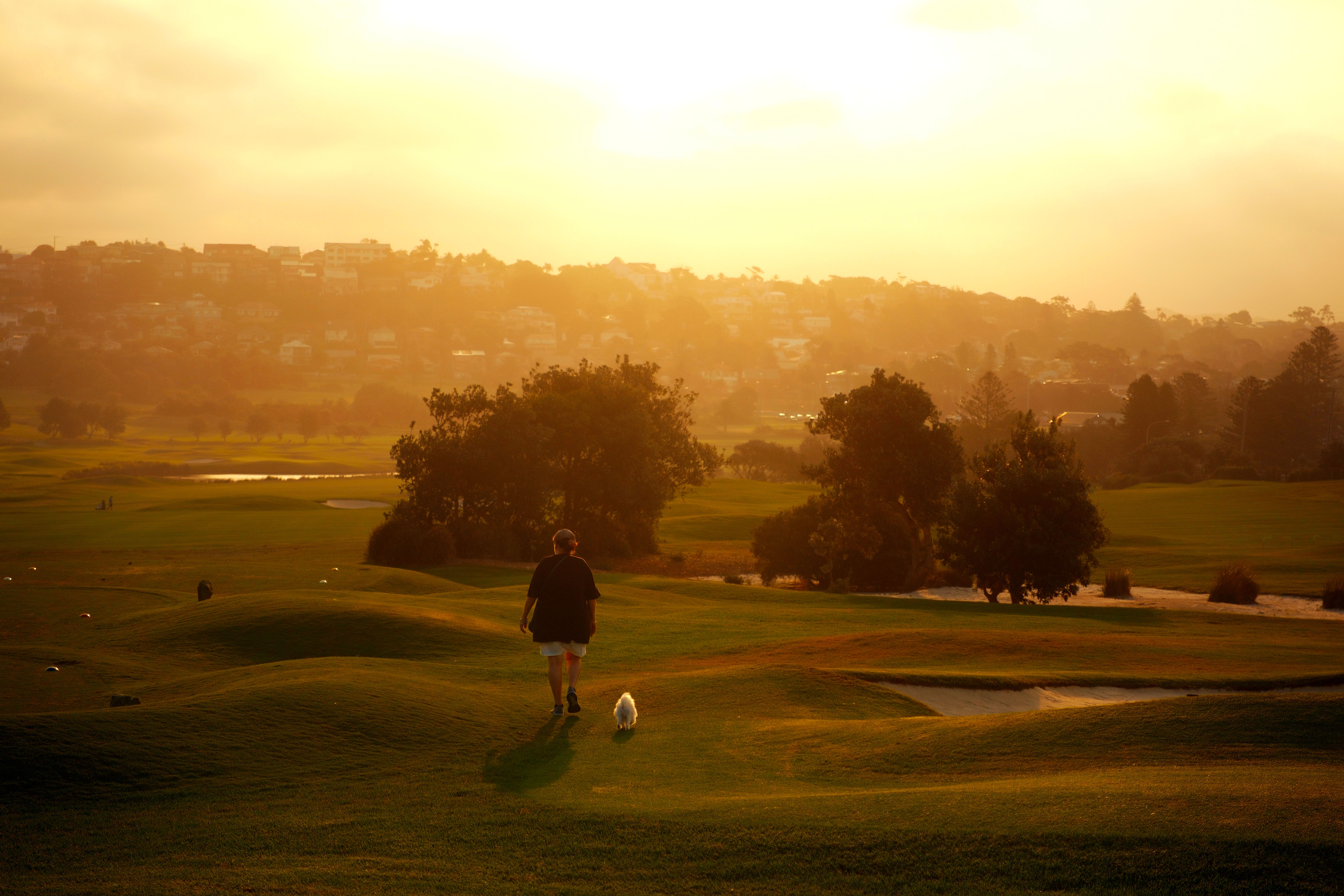 An aerial panoramic view of a luxury golf course at sunset, illustrating precision and elite sporting leisure.