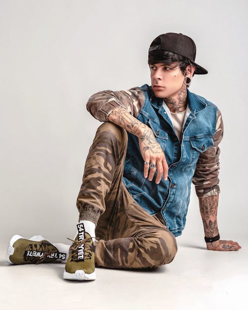 A man with tattoos sitting on the ground