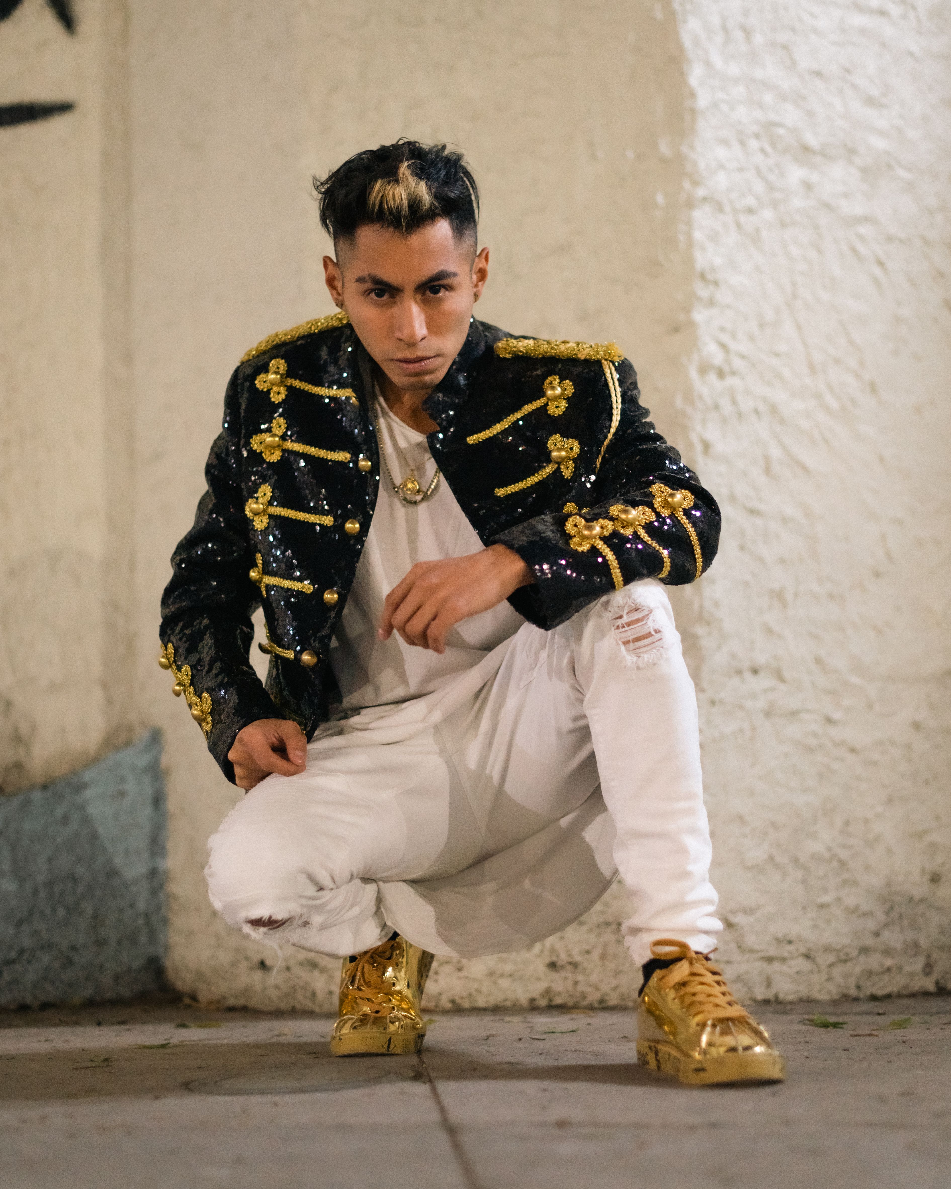 Stylish young adult posing in glamorous attire with a bold fashion statement in an urban setting.
