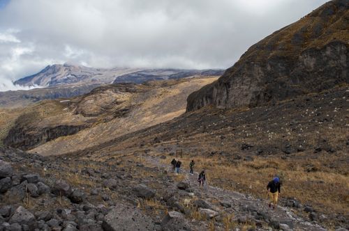 Free A group of hikers traverses a rugged mountain path under cloudy skies. Stock Photo