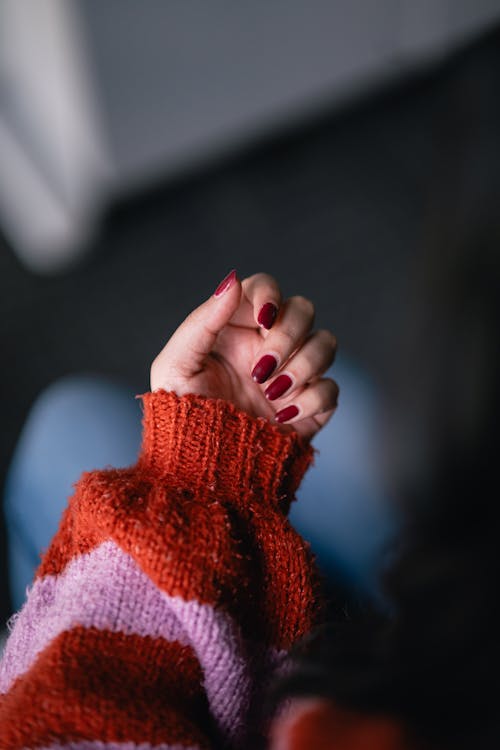A person's hand holding a red and white striped sweater