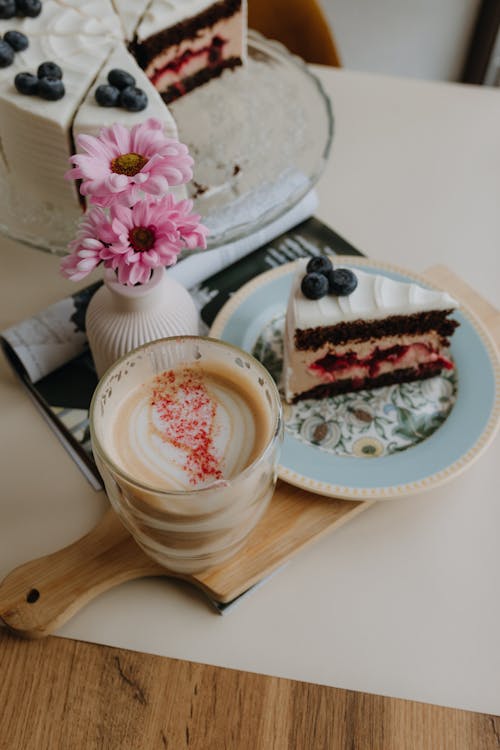 A cake and coffee on a table next to a plate of berries