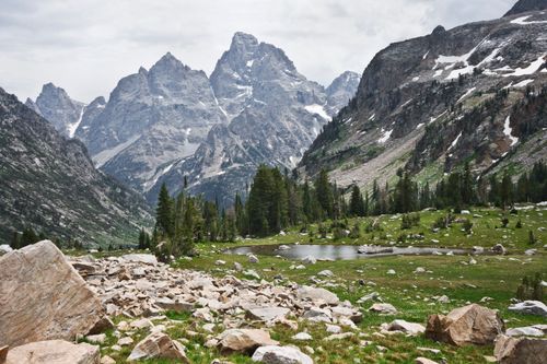 Free Majestic landscape featuring rugged mountains, lush greenery, and a serene pond in Grand Teton National Park, Wyoming. Stock Photo