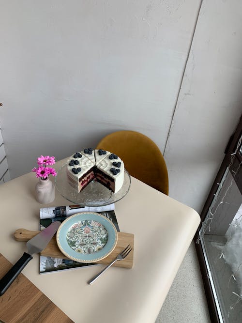 A cake on a table with a knife and fork