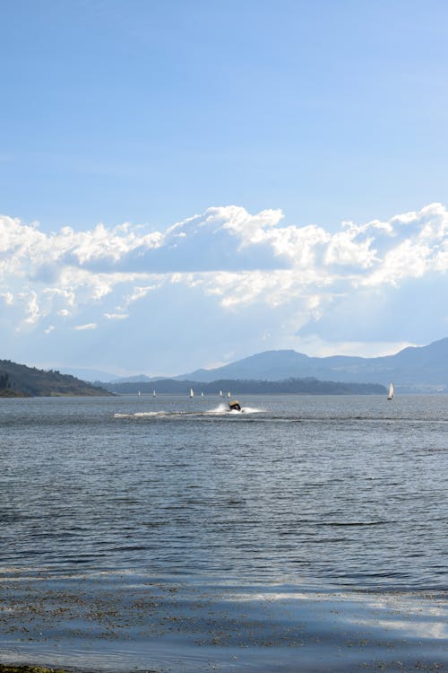 A boat is traveling on the water near mountains