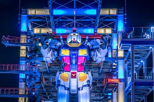 A large robot statue is lit up at night