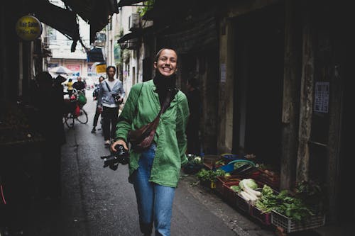 Smiling Woman Walking Beside Display Vegetables