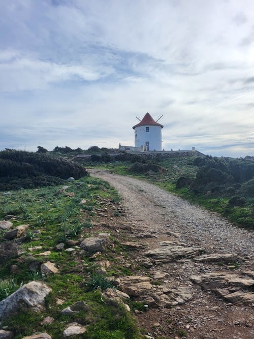 A trail leading to a lighthouse on a rocky hill