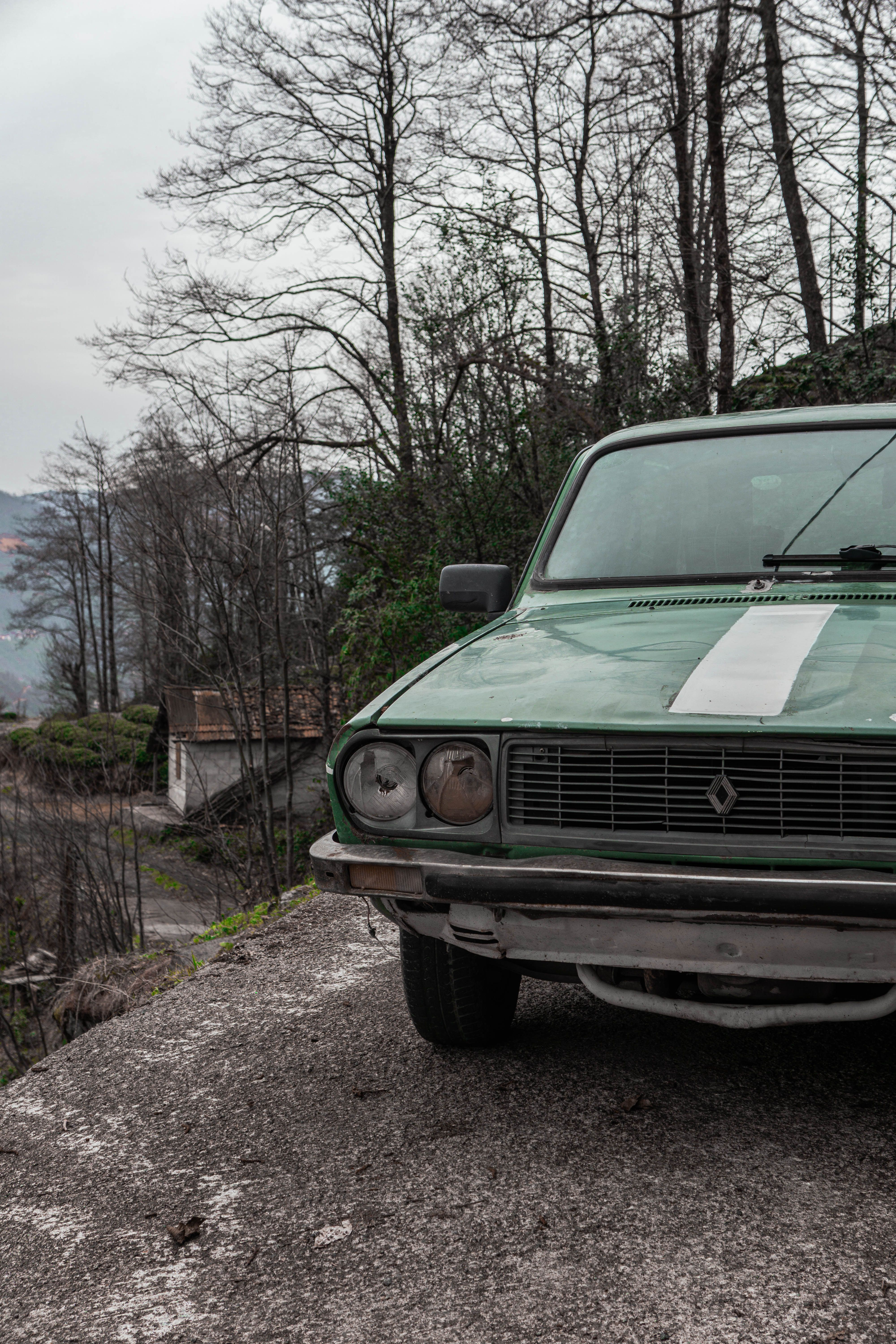 A green car parked on the side of the road · Free Stock Photo