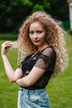 一位时尚女性身着黑色上衣和牛仔裤，在圣保罗的一个公园里摆姿势