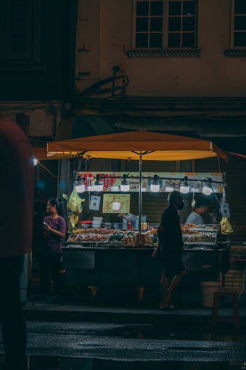 Gratis stockfoto met man loopt, marktkraam, steert fotografie