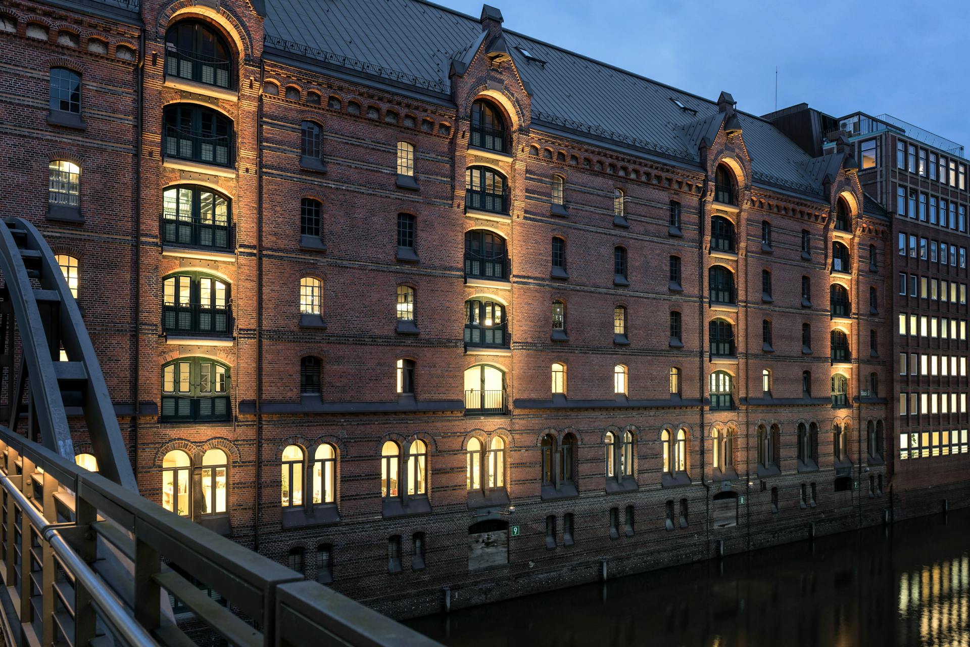 A beautifully lit historic warehouse in Hamburg's Speicherstadt district, captured at dusk.