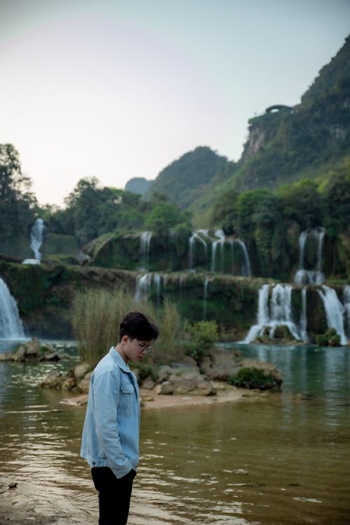 A man standing in front of a waterfall