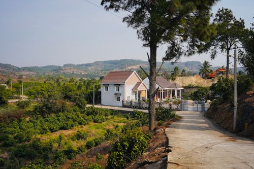 Free A charming countryside house amidst lush greenery in Lâm Đồng, Vietnam, under a clear blue sky. Stock Photo